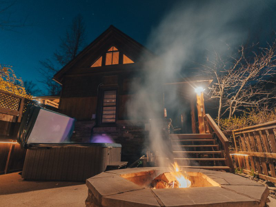 Exterior of cabin at night with fire pit in the front
