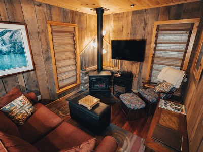 Cabin living room with small red couch and tv